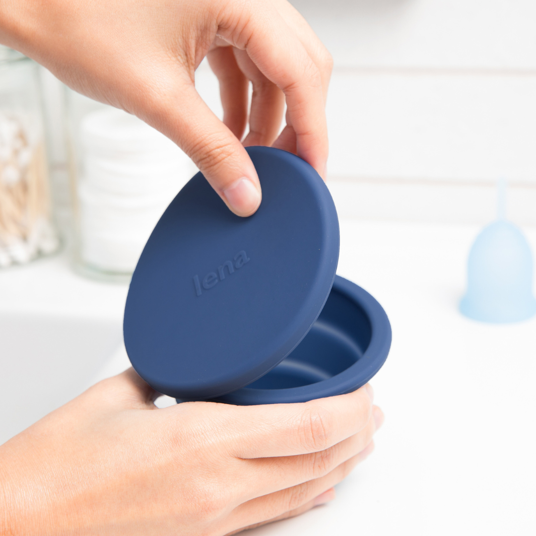 Hands opening the Lena Cleaning Container in dark blue