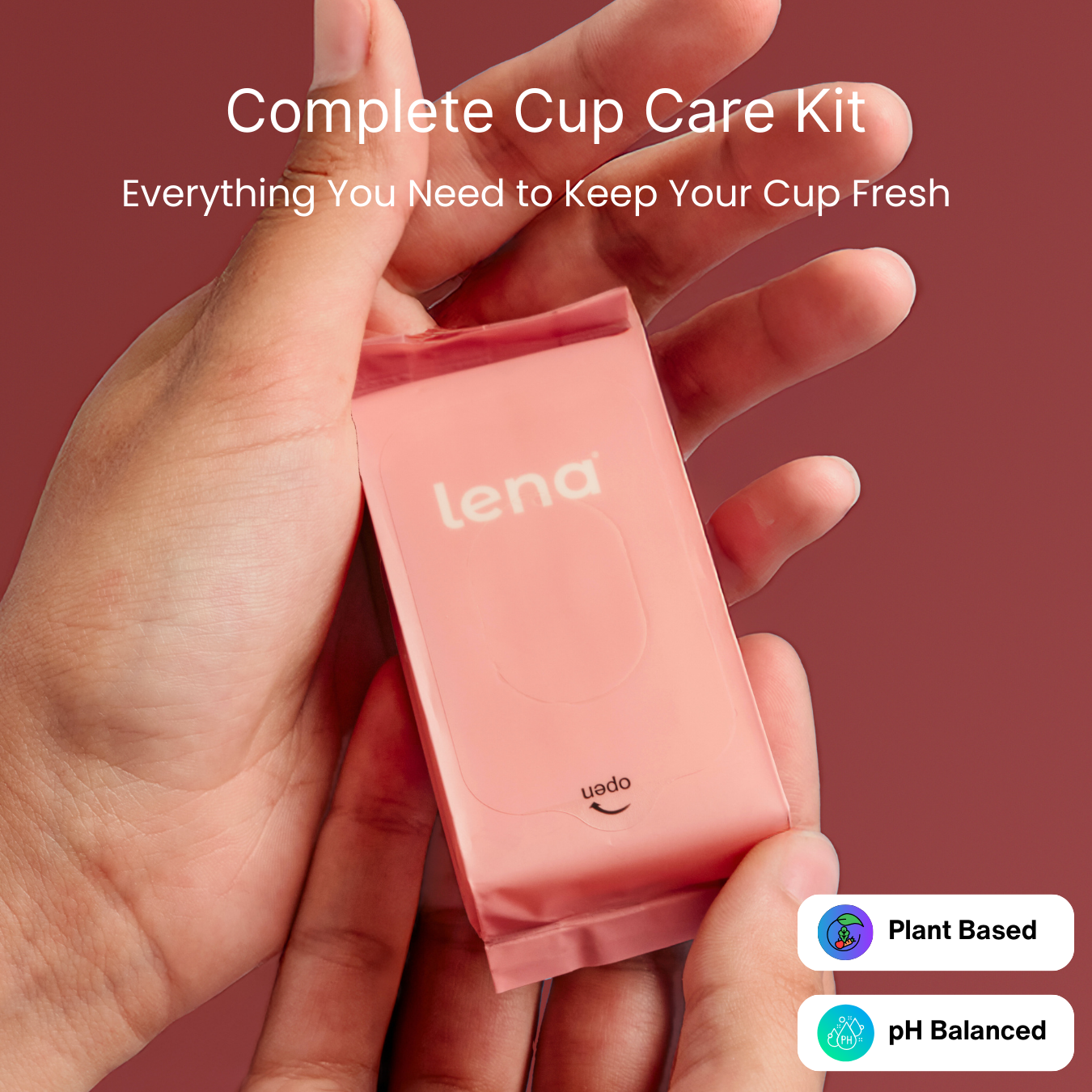 Hand holding a pink 'lena' cup care kit against a red background