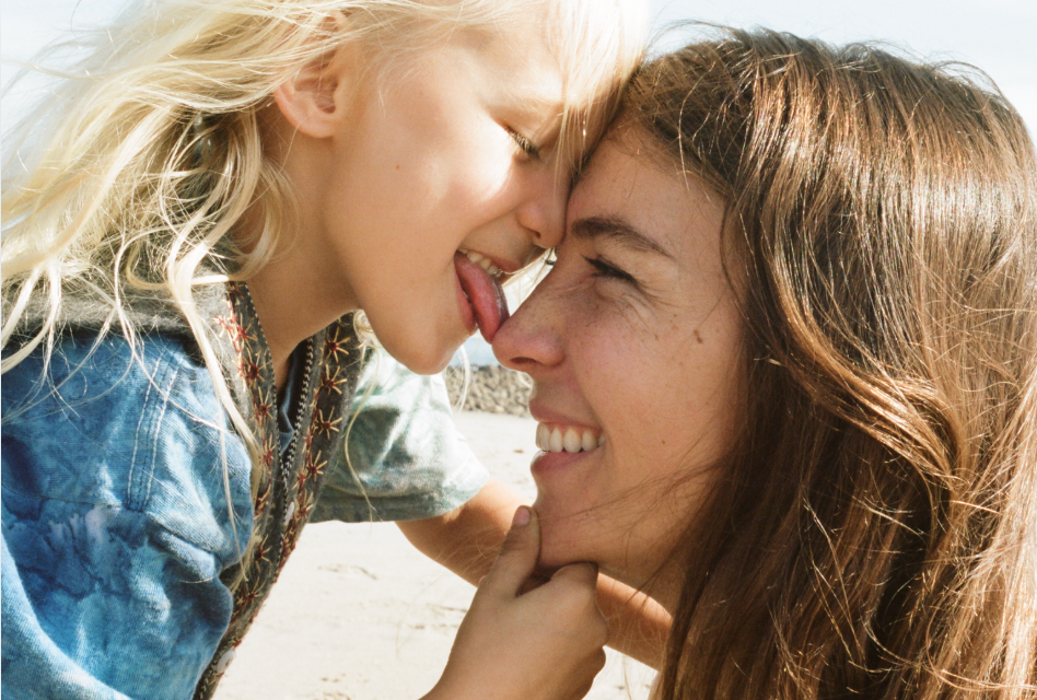 Young boy kissing a woman's nose