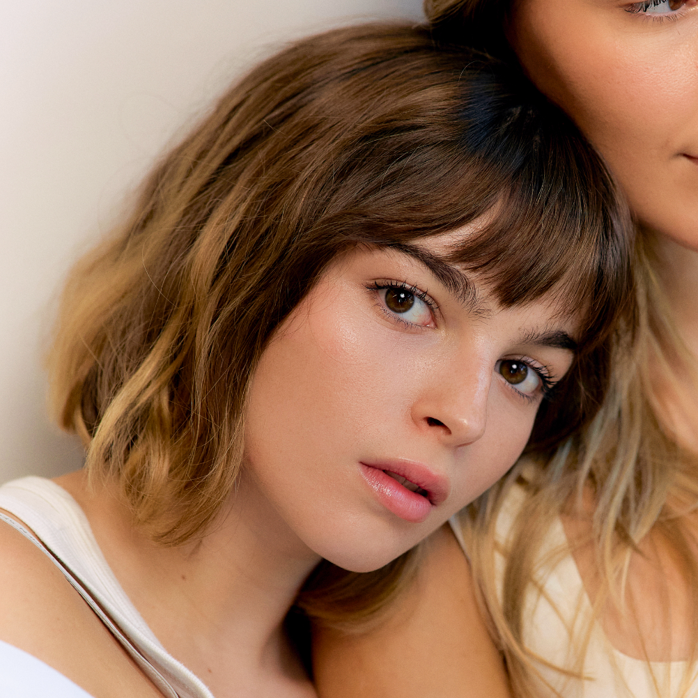 Two women with styled hair against a neutral background