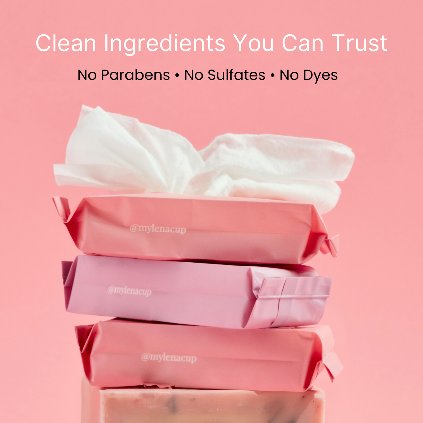 Stack of pink packaging with white tissue on a pink background, featuring text about clean ingredients.